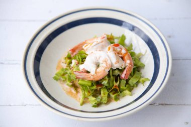 Kanat Fasulyesi ya da Betel Fındığı Baharatlı Salata Hindistan cevizi sütü, kavrulmuş acı biber ezmesi, kızarmış hindistan cevizi, tamarind, palmiye şekeri ve fıstık Tayland yemeği tarzı için beyaz tabak, arka plan olarak ahşap masa, üst görünüm