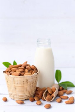Küçük bir şişede ev yapımı badem sütü ve beyaz arka planda izole edilmiş badem, en sağlıklı fındıklar ve en iyi beyin gıdalarından biri..