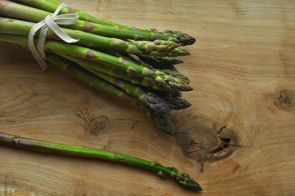 Bouquet d'asperges fraîches sur un fond en bois. végétalisme et les aliments crus — Photo