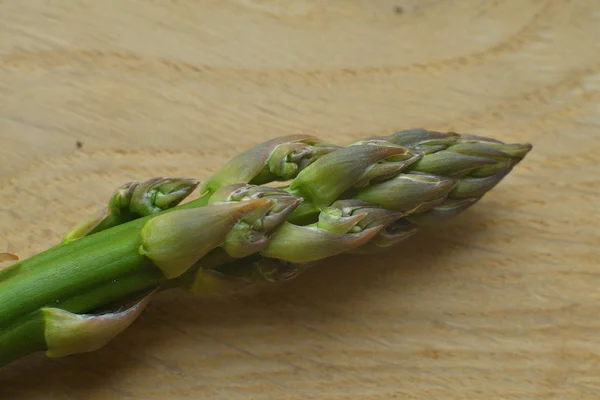 Mazzo di asparagi freschi su fondo ligneo. veganismo e cibi crudi — Foto Stock