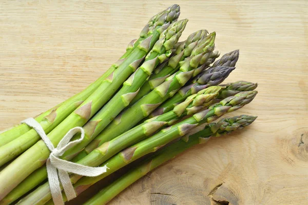 Bunch of fresh asparagus on a wooden background. veganism and raw foods — Stock Photo, Image