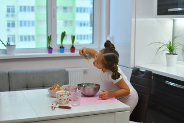 Sevimli küçük kız dil çırpMa hamuru yalar. Cupcakes hamur tatma