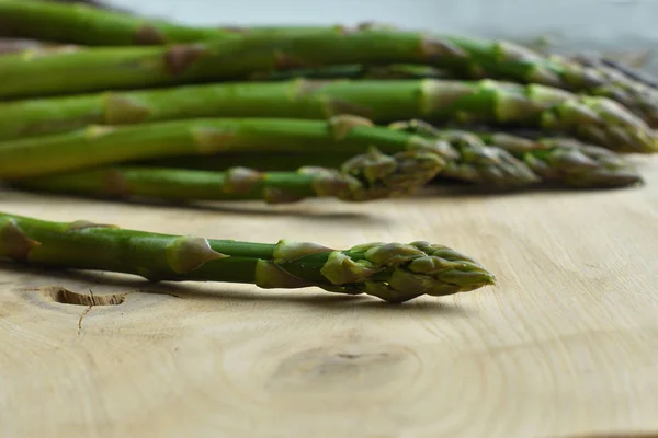 Bouquet d'asperges fraîches sur un fond en bois. végétalisme et les aliments crus — Photo