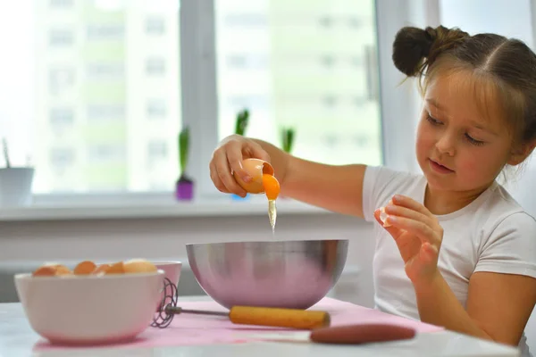 Маленькая девочка готовит печенье дома на кухне. Домашняя кухня . — стоковое фото