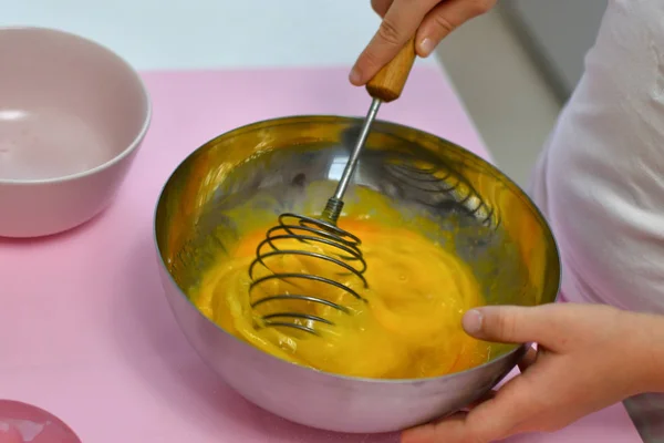 Девушка смешивания торт ингредиенты в миске смешивания взбивая сахар и яйца, чтобы сделать тесто — стоковое фото