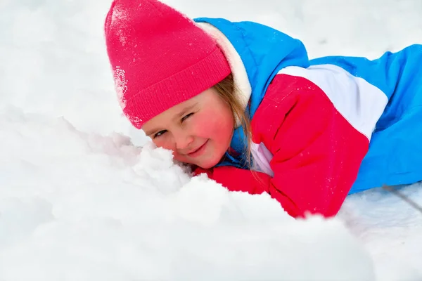 Lustiges kleines Mädchen, das bei einem Winterspaziergang mit Schnee spielt. Kinder spielen draußen. Winterspaß-Konzept. — Stockfoto