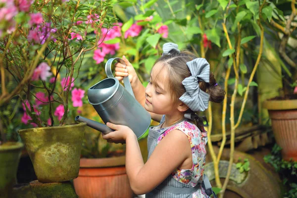 Çocuk bahar çiçekleri ekiyor. güzel kız bahçıvan bitkiler açelya. Bitkilerle ilgilenmesi. Kız kız sulama dan bitkiler sulama olabilir. Portre. — Stok fotoğraf