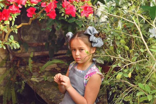 Enfant plantant des fleurs printanières. belle fille jardinier plantes azalée. Enfant prenant soin des plantes.Fille tenant un buisson d'azalée dans un pot de fleurs. Portrait . — Photo