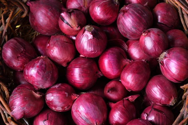 Cebolas vermelhas em uma cesta de madeira. A avitaminose de primavera — Fotografia de Stock