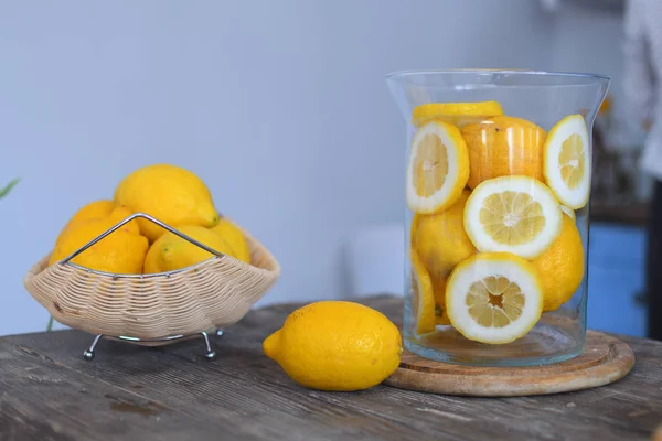 Limón en plato de madera sobre mesa de madera. Limones en rodajas. Fondo gris, cítricos, vitamina C — Foto de Stock