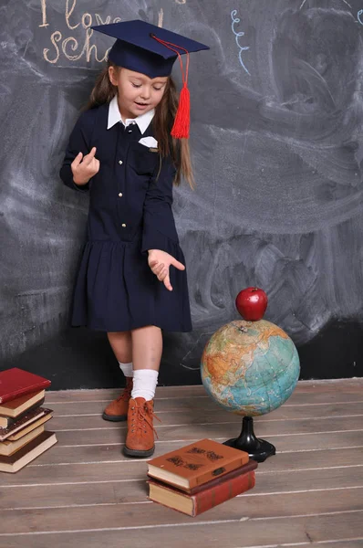 Portret szczęśliwej uczennice stojący w kapeluszu ukończenia szkoły. Idź do szkoły po raz pierwszy. Młoda dziewczyna odkrywania świata. — Zdjęcie stockowe