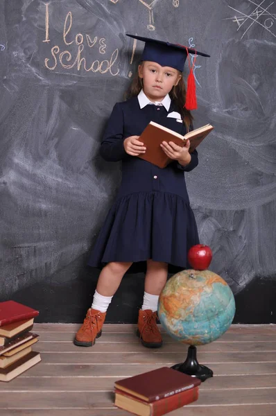 Portret szczęśliwej uczennice stojący w kapeluszu ukończenia szkoły. Idź do szkoły po raz pierwszy. Młoda dziewczyna odkrywania świata. — Zdjęcie stockowe