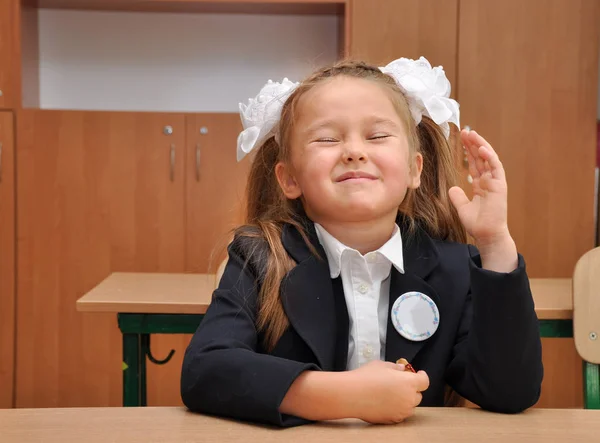 Pierwszy równiarka siedzi na biurku w szkole. Portret pięknej dziewczyny w klasie. — Zdjęcie stockowe