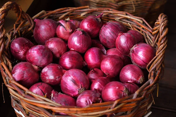 Červená cibule v dřevěném koši. Jarní avitaminóza. Zelenina v nákupním košíku, organická strava a čerstvá zelenina — Stock fotografie