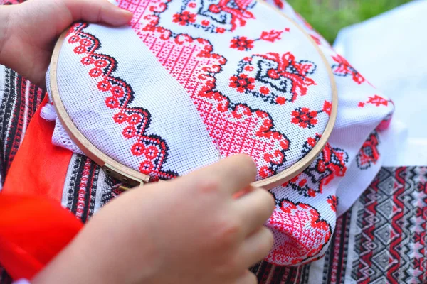 Meisje borduurwerk Rushnik. handen van meisje vrouw vrouw in Oekraïense traditionele shirt naaien borduurwerk patroon in borduurwerk frame. — Stockfoto