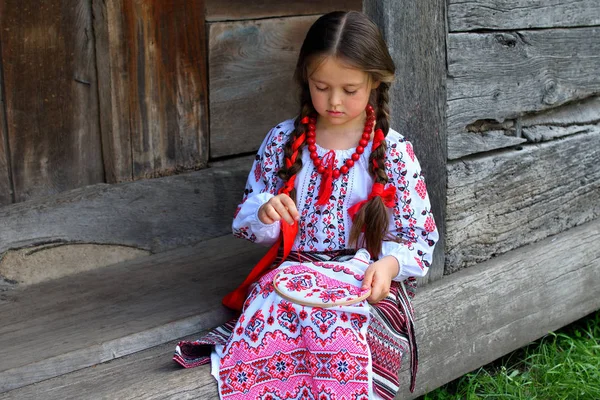 Meisje borduurwerk Rushnik. handen van meisje vrouw vrouw in Oekraïense traditionele shirt naaien borduurwerk patroon in borduurwerk frame. — Stockfoto