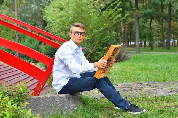 Boy with large abacus. Thoughtful schoolboy using a maths abacus calculation — Stock Photo, Image