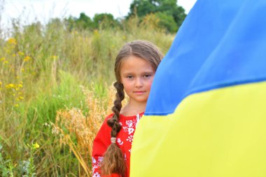 Ukraine patriotic concept. Beautiful girl in the Ukrainian national suit with Ukrainian flag. copyspace clipart