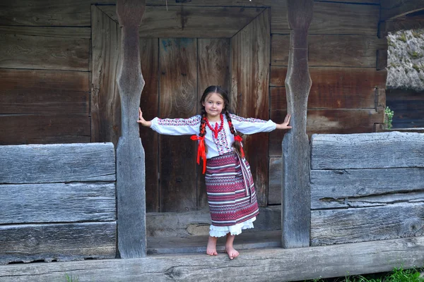 Ritratto di ucraino Bella ragazza in vyshivanka accanto alla vecchia casa di legno. ragazza nel ricamo.Concetto di tradizioni nazionali — Foto Stock