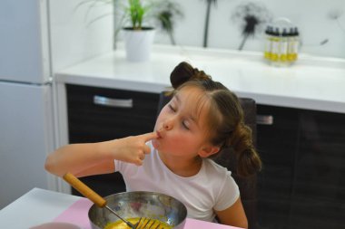 Küçük kız evde mutfakta kurabiye hazırlıyor. Ev yapımı yemekler pişirmek. Yemek pişirmek eğlencelidir. Paskalya pastası pişirme için Malzemeler