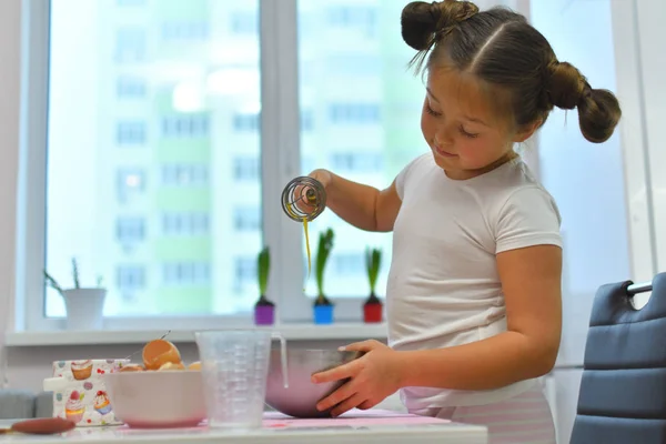 Niña preparando galletas en la cocina en casa. Cocinar comida casera. Cocinar es divertido. Ingredientes para hornear pastel de Pascua — Foto de Stock