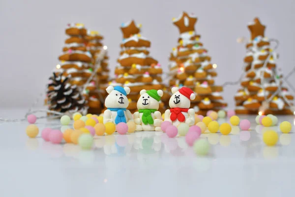 gingerbread Christmas tree.Christmas Gingerbread cookie with multi-colors caramel.Sugar white bears in red hat on white background next to multi-colors caramel