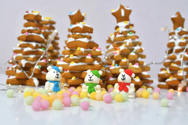 Пряничные рождественские елки Рождественские пряники печенье с многоцветной caramel.Sugar белых медведей в красной шляпе на белом фоне рядом с многоцветной карамели — стоковое фото