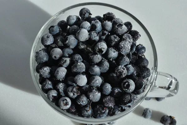 Blueberries in a glass cup on white background. — ストック写真