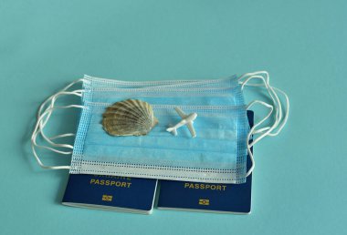 Mavi arka planda Ukrayna pasaportları ve tıbbi maskeler. Mavi arka planda seyahat konsepti. COVID-19 ile iptal edilmiş tatil seyahatleri. Covid-19 'un turizm sektörüne etkisi. Küresel karantina