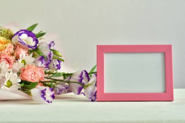 Bir buket narin gül, Eustoma, ortanca ve fotofram. Çiçek kartı modeli. Anneler günü, sevgililer günü, doğum günü. Uzayı kopyala Tebrik şablonu. Düğün davetiyesi. Seçmeli odak