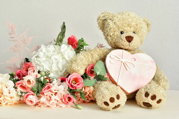 bouquet of delicate pink flowers and present box.Teddy bear. Valentines Day 14 February.Greeting card for Birthday, Woman or Mothers Day. I love you concept.Good morning.Selective focus.Copy space.