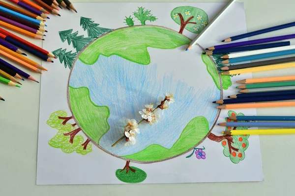 drawing planet earth in a protective mask.Child girl draws planet for earth day. Protection of enviroment, Save our planet , save world and unity.Ecology concept.Covid-19. Selective focus