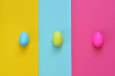 Paskalya yumurtaları ve renkli arka planla yapılmış. Bahar tatili konsepti. Yaratıcı kopyalama alanı. Düz yatıyordu.