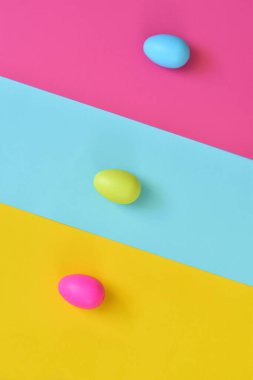 Paskalya yumurtaları ve renkli arka planla yapılmış. Bahar tatili konsepti. Yaratıcı kopyalama alanı. Düz yatıyordu.