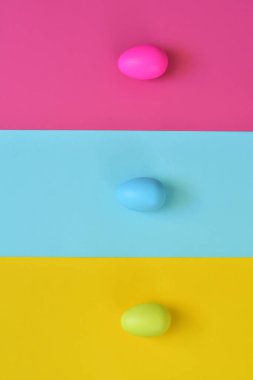 Paskalya yumurtaları ve renkli arka planla yapılmış. Bahar tatili konsepti. Yaratıcı kopyalama alanı. Düz yatıyordu.