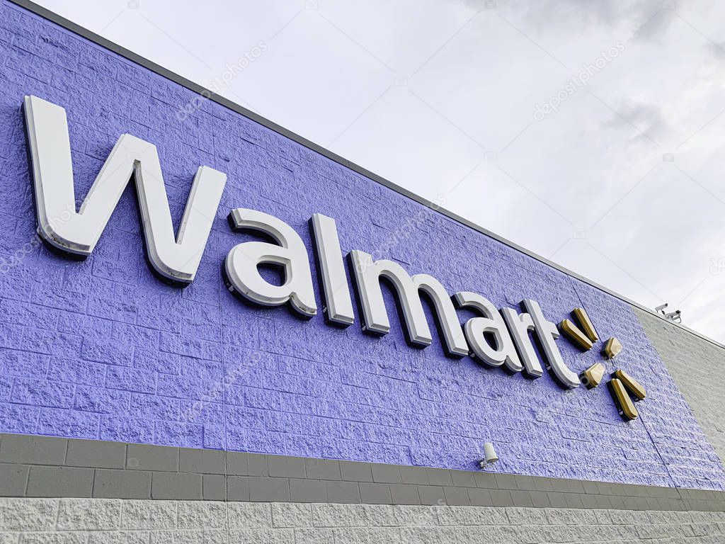 Vidalia, Georgia / USA - June 13, 2019: The prominent lighted 3D brand and logo of Walmart on the top portion of its big box store facade in Vidalia, Georgia, USA.