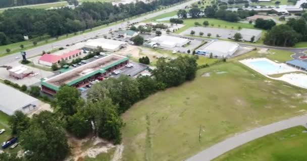 Vue aérienne d'une banlieue américaine typique montrant un mélange d'espaces résidentiels, commerciaux et naturels reliés par des allées aux rues et aux routes de campagne avec des bandes d'espaces pour les parkings, pelouses, arbres, buissons et autres plantations .