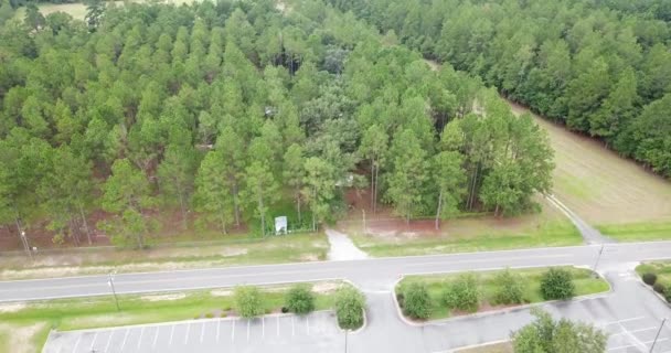 駐車場 その他のプランテーションのためのスペースの広がりを持つ道路や田舎道への車道で接続された住宅 自然空間のミックスを示す典型的なアメリカの郊外地域の航空写真 — ストック動画