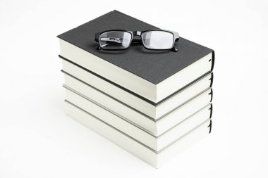A Neatly Stacked Set Of Five Books With Reading Glasses clipart