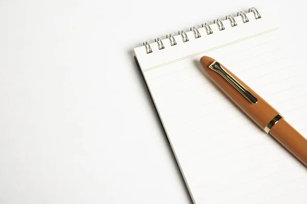 Pluma estilográfica naranja con cuaderno en espiral — Foto de Stock