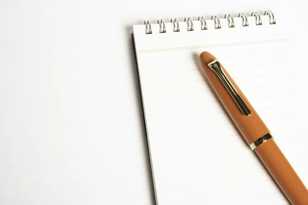 Pluma estilográfica naranja con cuaderno en espiral — Foto de Stock