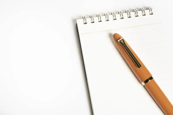 Pluma estilográfica naranja con cuaderno en espiral — Foto de Stock