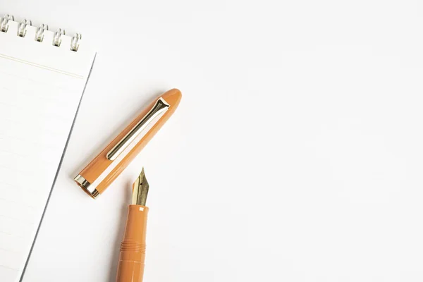 Oranje Vulpen met spiraal afhankelijke notebook — Stockfoto