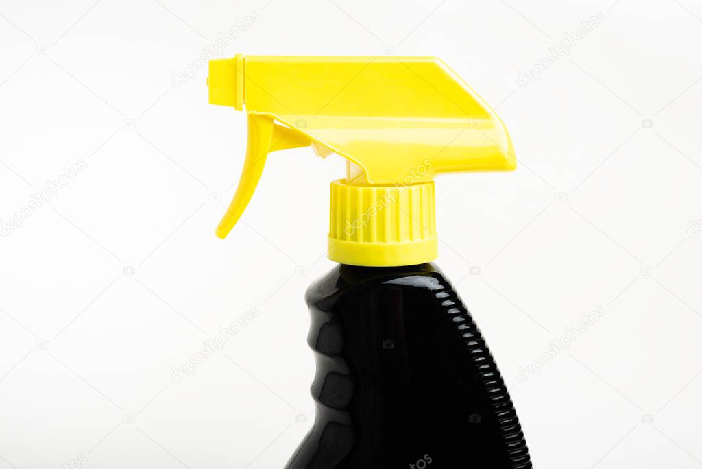 A close-up of the top portion of a black and yellow liquid spray plastic dispenser bottle set on a plain white background.