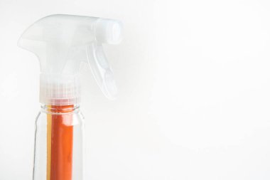 Şeffaf bir nozülün üst kısmının yakın plan resmi. Plastik sprey sprey şişesi sade beyaz arka planda..
