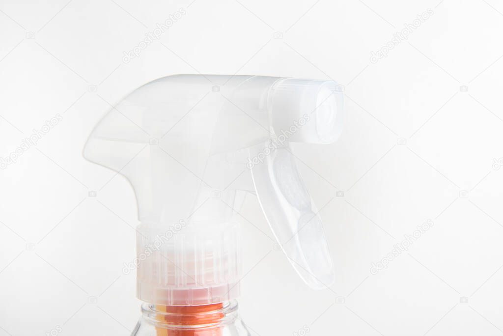 A close-up of the top portion of a transparent nozzle liquid spray plastic dispenser bottle set on a plain white background.