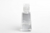 A termék lövés egy általános zsebméretű átlátszó kézfertőtlenítő műanyag adagoló palack készlet egy egyszerű fehér háttér.