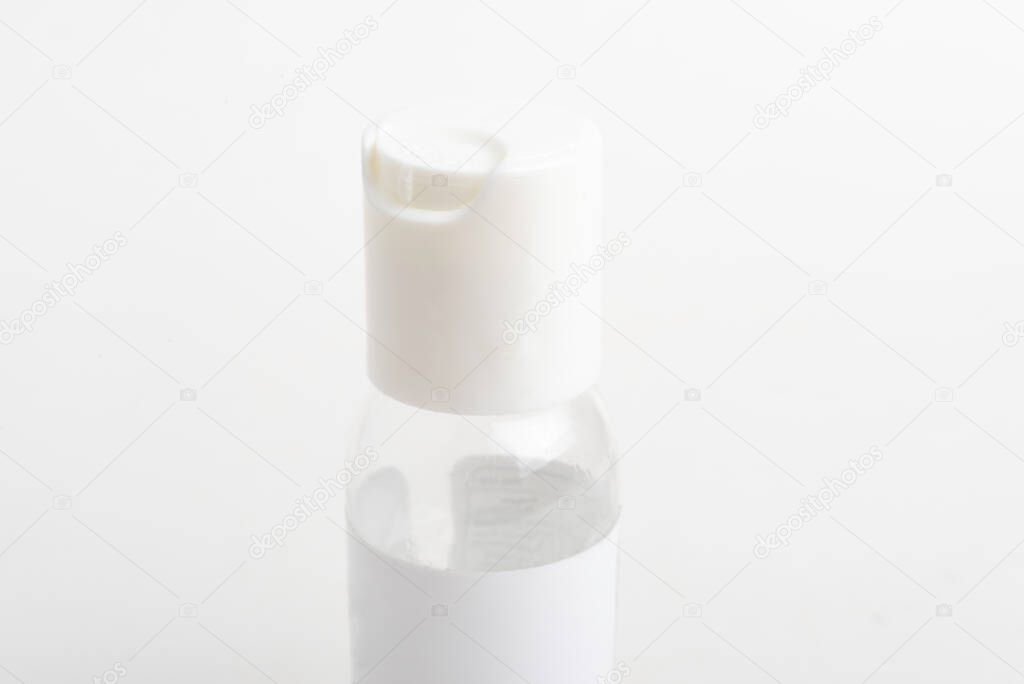 A close-up product shot of the top white cap of a pocket-size transparent hand sanitizer plastic dispenser bottle set on a plain white background.