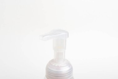 Köpük sabun şişesinin şeffaf üst pompasının beyaz arka plan üzerine kurulmuş yakın plan görüntüsü..