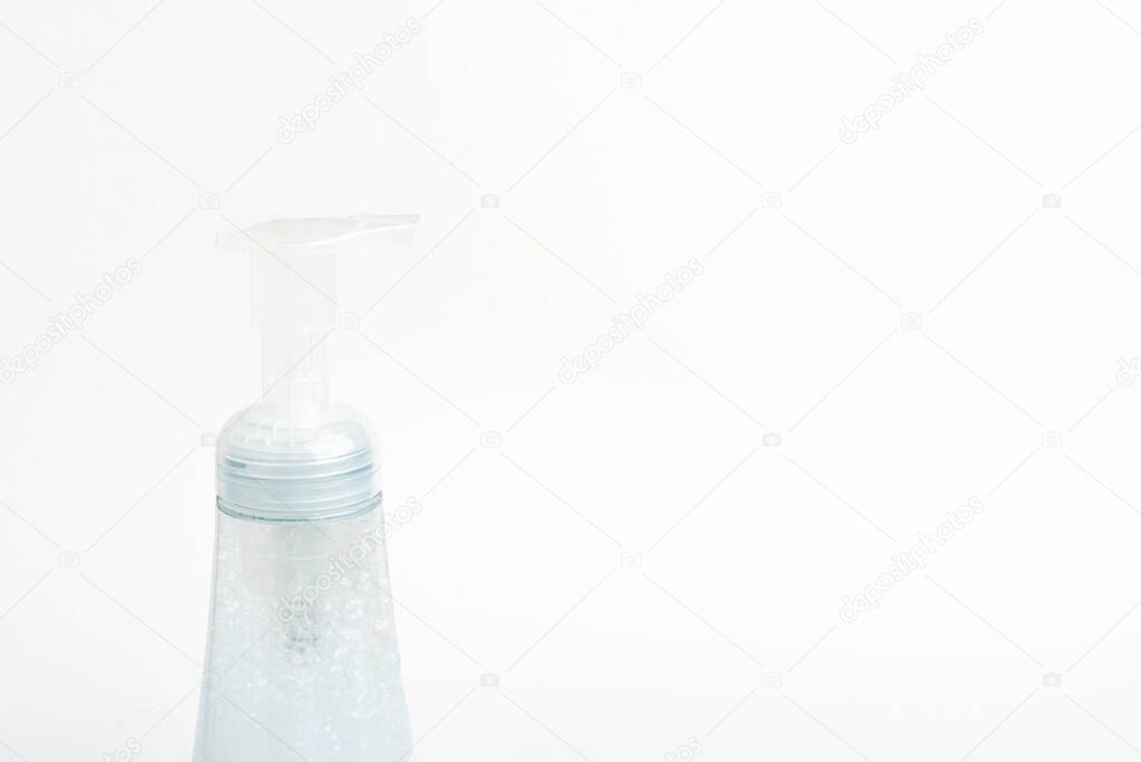 A close-up image of the translucent top pump and bottle of a foam soap plastic dispenser set on a white background.